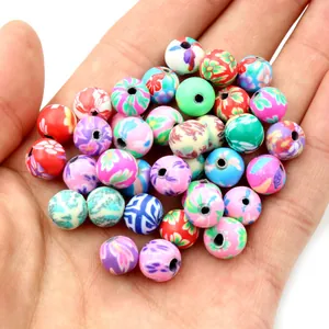 Perles rondes colorées en pâte polymère pour bijoux DIY présentées dans la main