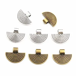 Close-up of fan-shaped alloy charms in antique silver and bronze for DIY jewelry making