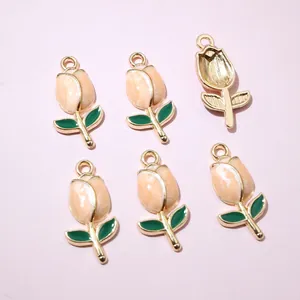 Detailed macro view of enamel tulip charms with golden frames for DIY jewelry making