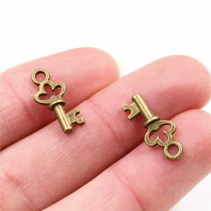Makroaufnahme kleiner Vintage-Bronze-Schlüsselanhänger auf einem Finger für die Größe