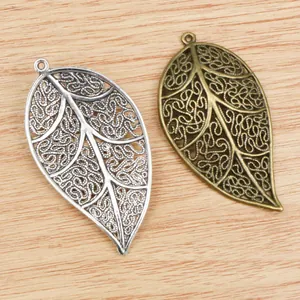 Makroaufnahme von hohlen Blatt-Anhängern aus Legierung in Silber und Bronze für DIY-Schmuck
