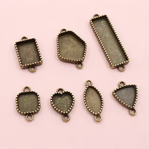 Vintage Bronzelegierung geometrische Schmuckfassungen für DIY-Anhänger auf rosa Hintergrund