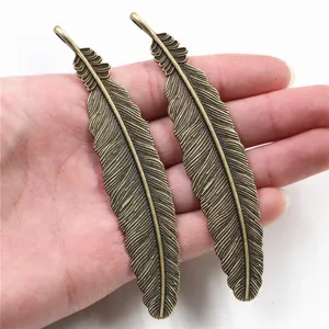 Paar große Federn-Anhänger aus Bronzelegierung für DIY-Schmuck, in der Hand zur Größe