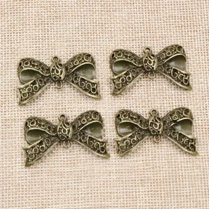 Antike Bronze-Schleifenanhänger mit Hohlmuster und Doppelösen für DIY-Schmuckherstellung