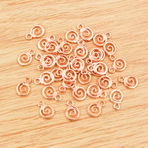 Spiralförmige Roségold-Legierung Anhänger für DIY-Schmuck auf hellem Holzuntergrund