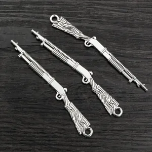 Makroaufnahme von silbernen Gewehr-Anhängern aus Legierung mit feinen mechanischen Details