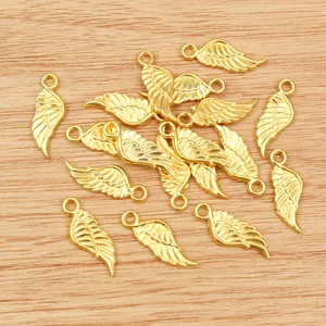 Goldene Herz-Flügel Anhänger aus Legierung für DIY-Schmuck auf Holzoberfläche