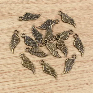 Makroaufnahme von Vintage-Bronze-Flügelanhängern mit Federstruktur für DIY-Schmuck