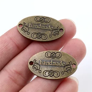 Makroansicht der handgefertigten ovalen Bronzeanhänger mit Doppellöchern für DIY-Schmuck