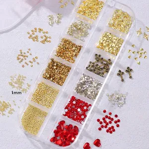 Detailed view of red and white glass rhinestones and gold metal nail art charms