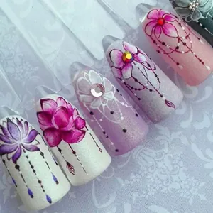 Detalle de pegatinas para uñas pintadas a mano con diseños florales, purpurina y pedrería