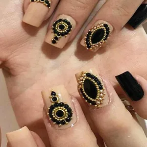 Nail art με μαύρα πετράδια, χρυσές ατσάλινες χάντρες και λευκά μαργαριτάρια σε ροζ νύχια