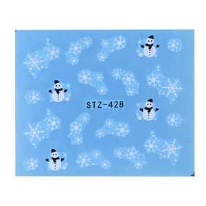 Close-up of winter nail stickers featuring white snowflakes and snowmen patterns