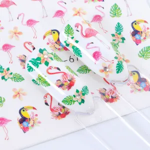 Detail van nagelstickers met roze flamingo's en groene tropische palmbladeren