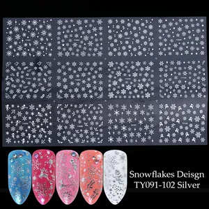 Macro shot of silver 3D snowflake nail stickers with festive deer and star patterns