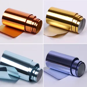Detalle de cuatro rollos de papel metálico para uñas en naranja, dorado, azul y púrpura brillante