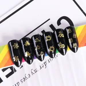 Macro detail of black Christmas nail tips with gold reindeer and snowflake patterns