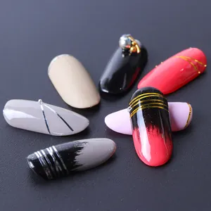 Vue macro de faux ongles variés avec lignes métalliques et décorations de perles