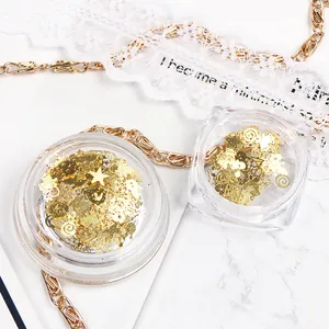 Macro view of Christmas nail art gold metal sequins with stars and bells in boxes