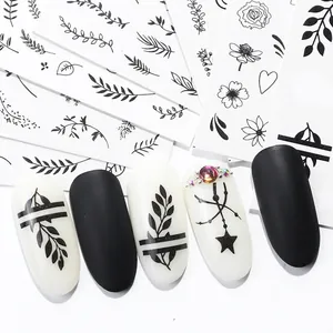 Black leaf and geometric nail art stickers with star patterns on matte manicured nails