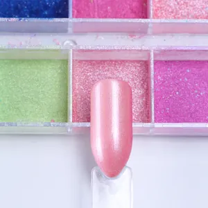 Gros plan de la finition poudre à ongles nacrée rose avec palette de pigments