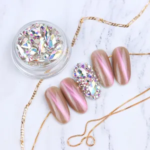 Close-up of mixed shape AB crystals in a jar and applied on pink cat-eye nails