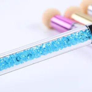 Vue macro du manche d'outil nail art rempli de cristaux bleus brillants et scintillants