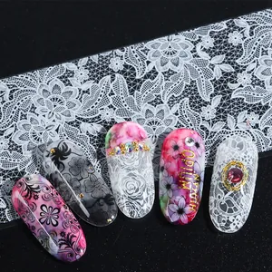 Vista macro detallada de encaje negro y diseños florales de mármol en láminas de uñas