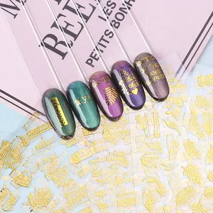 3D gold nail art stickers with Russian text and feather patterns on dark manicured nails