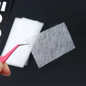 Extensions d'ongles en fibre de soie et pince rose sur un fond noir à contraste élevé