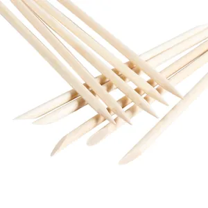 Macro detail of dual-tip orange wood nail sticks for cleaning and cuticle care