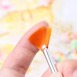 Orange fan nail brush with soft synthetic bristles and silver metal ferrule for manicure