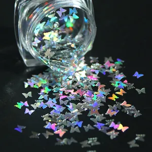 Vue macro de paillettes papillon holographiques se dispersant d'un pot sur fond noir
