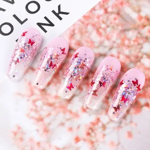 Primer plano de uñas postizas degradadas rosas con purpurina y lentejuelas mariposa