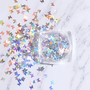 Vista macro de lentejuelas holográficas de mariposa para uñas en caja cuadrada