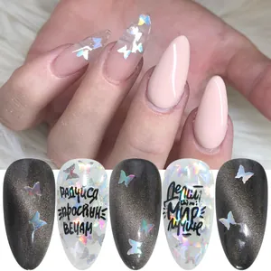 Uñas postizas almendradas con mariposas holográficas y texto ruso sobre fondo de piel blanca