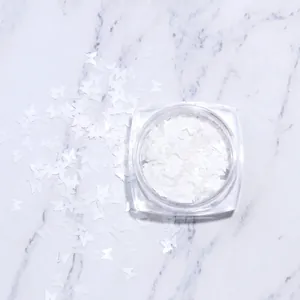Vue macro de paillettes pour ongles papillon blanc avec flacon de rangement transparent