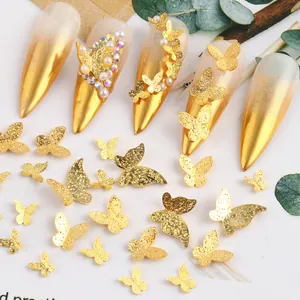Amuletos de uñas mariposa dorados 3D con acabado mate y detalles de perlas