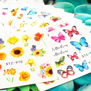 Close-up of STZ-970 colorful butterfly and flower nail water slide decals on green stones