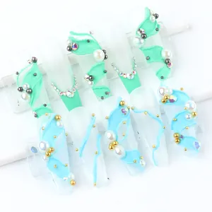 Détail de faux ongles cercueil vert menthe et bleus avec reliefs 3D et perles fines