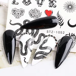 Macro shot of Gothic nail stickers featuring black snakes and silver rhinestones