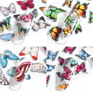 Détail de stickers à ongles papillon holographiques avec reflets laser sur ongles clairs