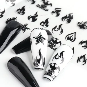 Primo piano di motivi a fiamma nera e stelle su unghie a bara lunghe, nail art gotica