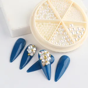 Close-up of white flatback pearls and rhinestones for nail art in a round storage box