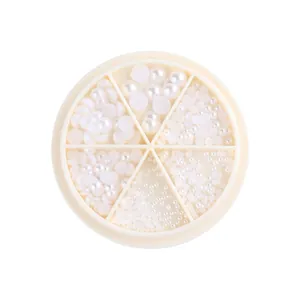 Nail art flatback white pearls in various sizes stored in a 6-compartment wheel case
