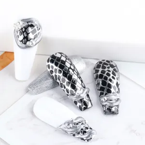 Close-up of snake skin pattern nails with 3D silver relief and faux pearls details