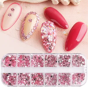 Close-up of 12-grid nail art kit featuring pink resin flowers and crystal rhinestones