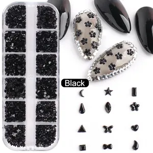 Détail macro de boîte 12 grilles avec breloques nail art noires, lunes et étoiles