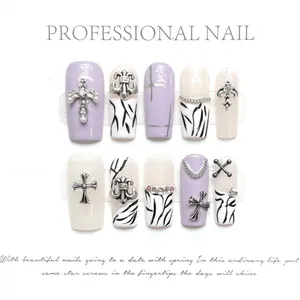 Handmade zebra print press-on nails with silver cross and pearl accents in coffin shape