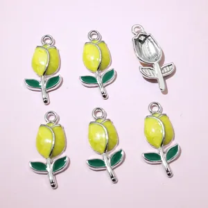 Macro view of six yellow tulip flower charms for DIY jewelry making with silver hooks